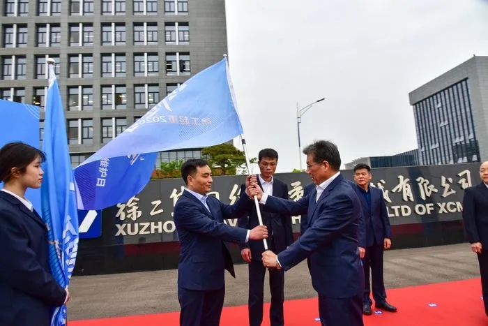 FH官网起重机械事业部副总经理史先信向FH官网重型服务备件中心总经理姜凡科、FH官网履带客户服务中心总经理郝敏、FH官网塔机营销公司副总经理吴建明以及供应商、经销商代表授旗